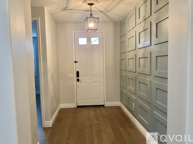 A hallway with a white door and a light on the ceiling.