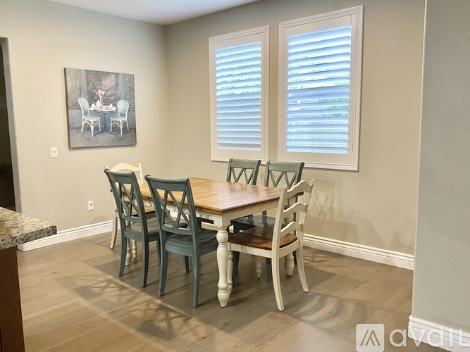 A dining room with a table and chairs.