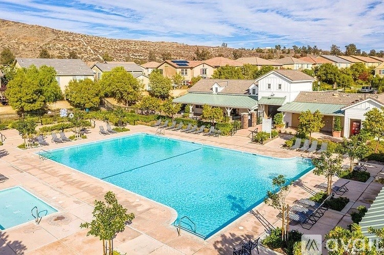 A large swimming pool surrounded by houses and trees.