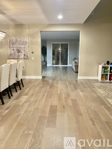 A hallway with wooden floors and a framed picture on the wall.