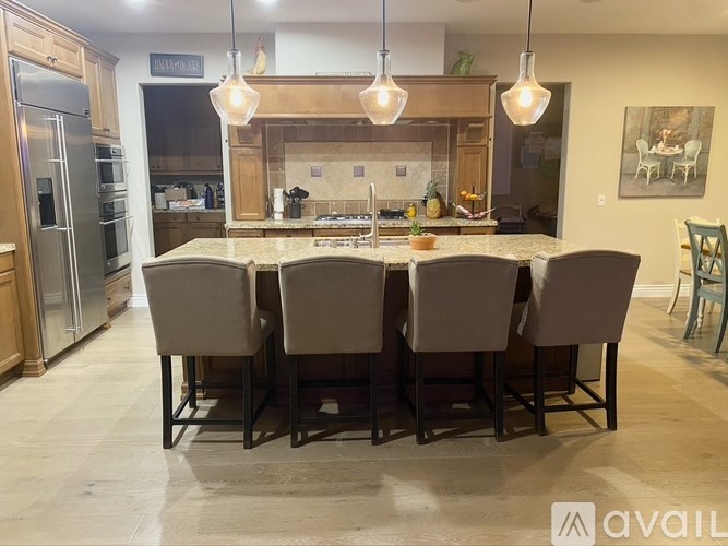 A kitchen with a table and chairs in the foreground and a painting on the wall in the background.