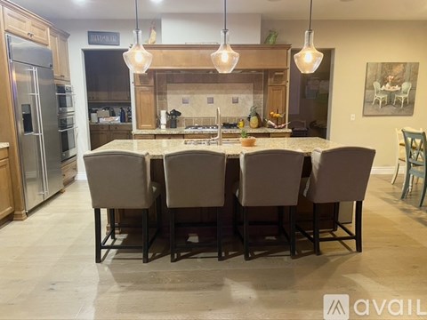 A kitchen with a table and chairs in the foreground and a painting on the wall in the background.