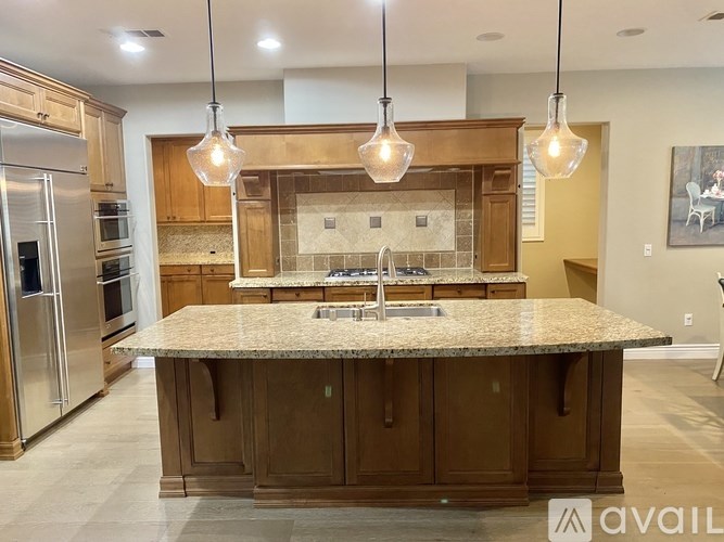A kitchen with a granite countertop and wooden cabinets.