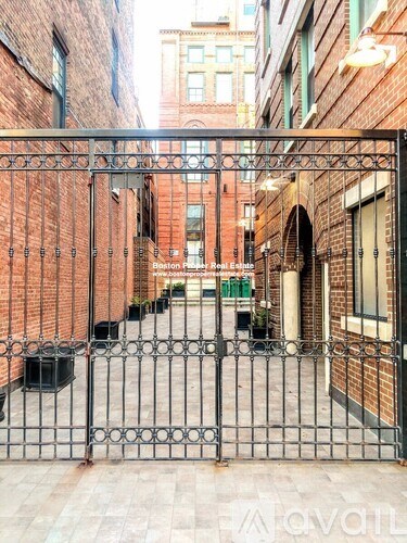 A black metal gate blocks the entrance to a brick building.