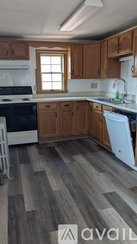 A kitchen with wooden cabinets and a white dishwasher.