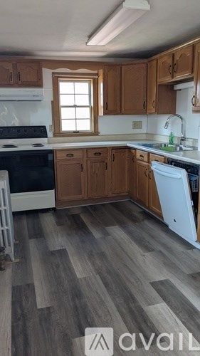 A kitchen with wooden cabinets and a white dishwasher.