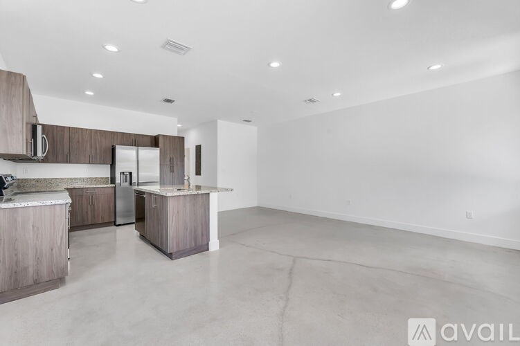 A spacious kitchen with a bar area and a refrigerator.