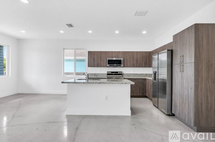 A modern kitchen with a white island and stainless steel appliances.