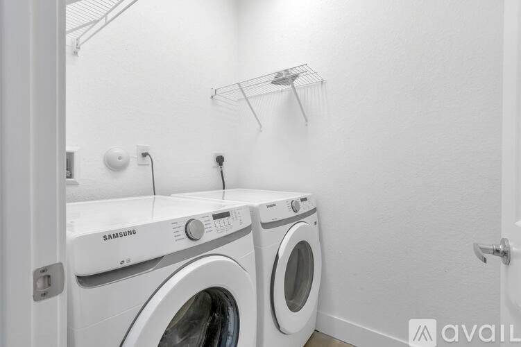 A white Samsung washing machine and dryer in a small laundry room.