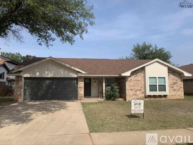 A house with a sign that says "For Sale" in front of it.