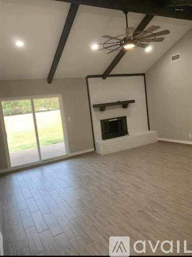 A room with a fireplace and a ceiling fan.