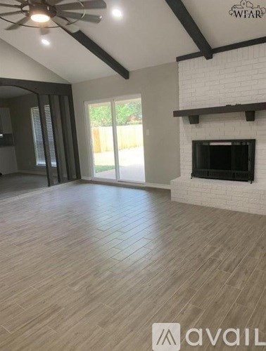 A living room with a fireplace and a ceiling fan.