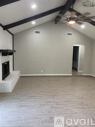 A living room with a fireplace and a ceiling fan.