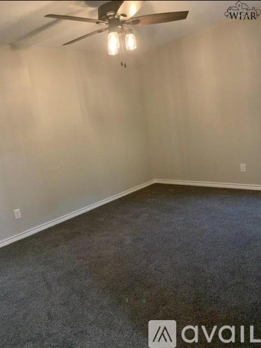 A room with a ceiling fan and carpeted floor.