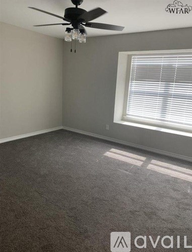 A room with a ceiling fan and a window with blinds.