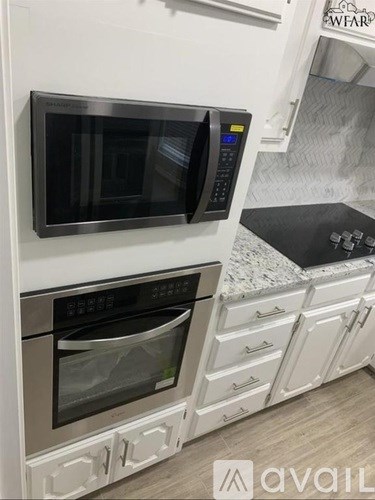 A modern kitchen with a stainless steel microwave and oven.