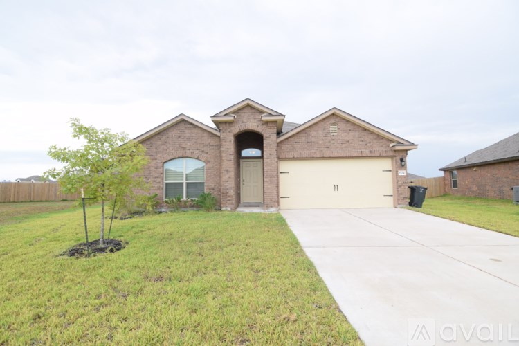 A house with a brown brick exterior and a large front yard.