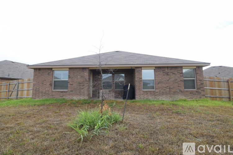 A house with a brown roof and a fence in the background.