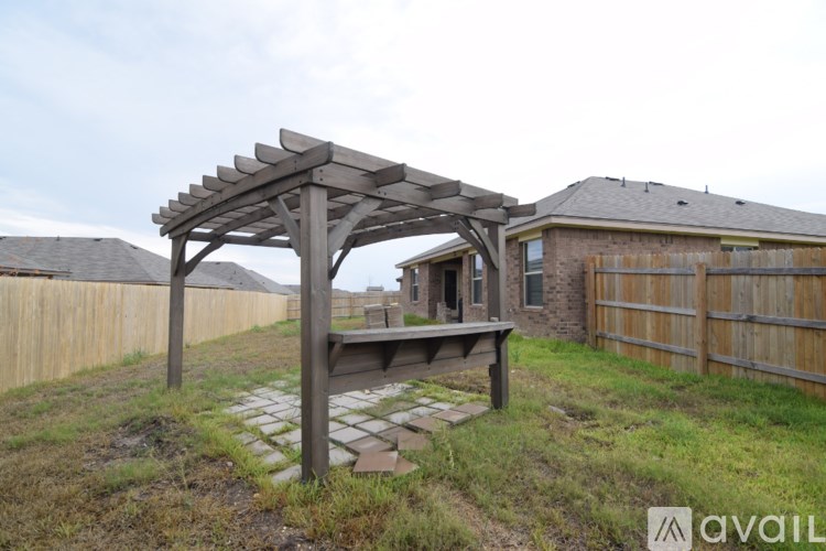 A wooden pergola is attached to a house.