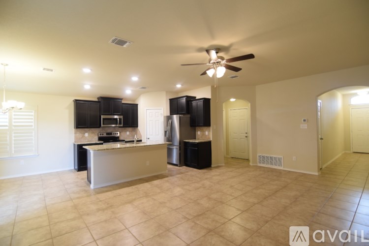 A kitchen with black cabinets and a white island.
