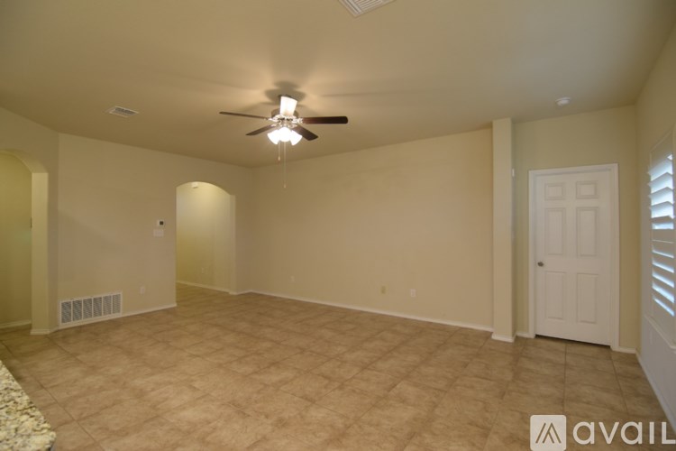 A room with a ceiling fan and beige carpet.