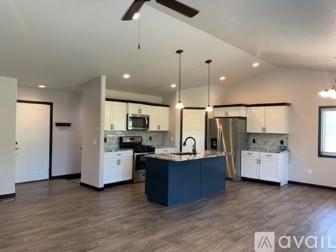 A modern kitchen with a dark blue island in the middle.