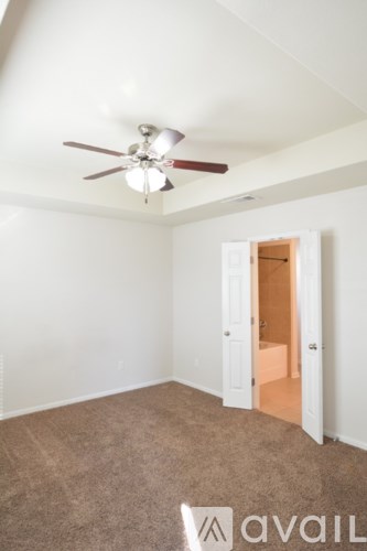 A room with a ceiling fan and carpeted floor.