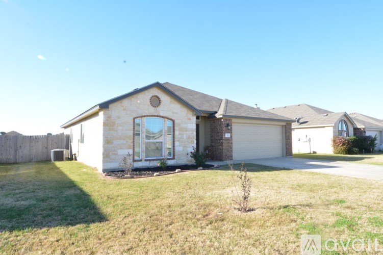 A house with a garage and a driveway in front.