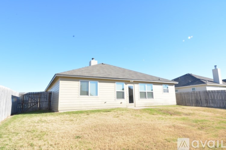 A house with a fence and a grassy yard.