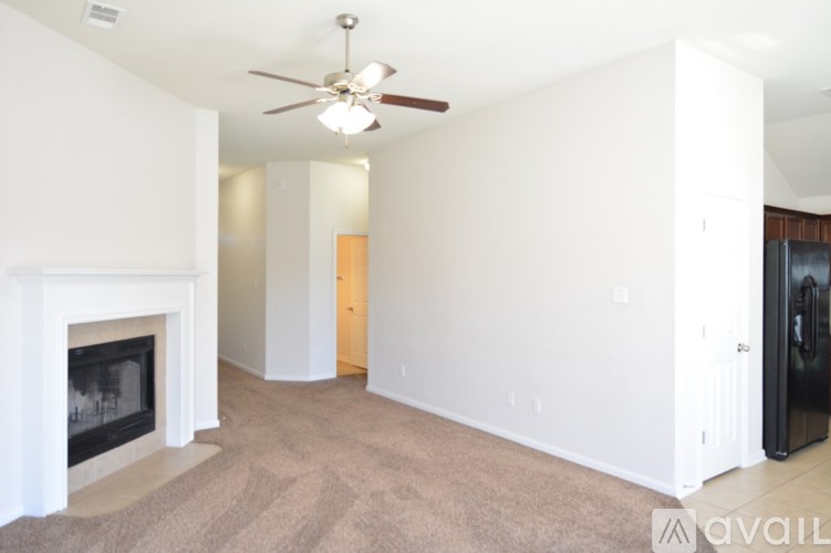 A living room with a fireplace and a ceiling fan.