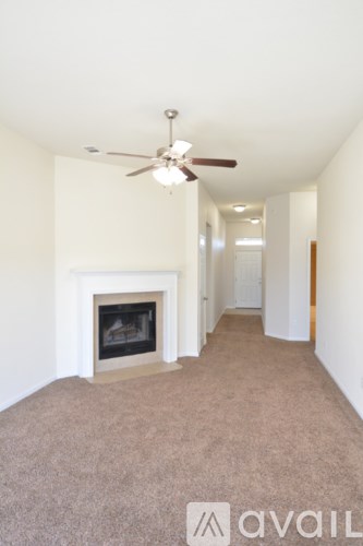 A living room with a fireplace and a fan.