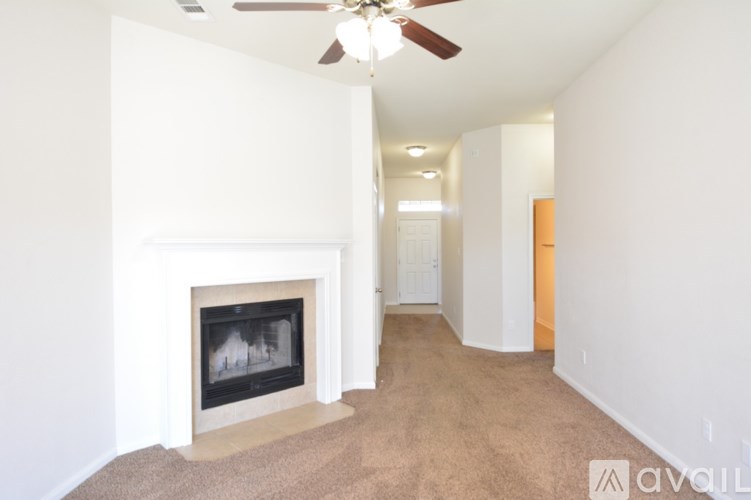A room with a fireplace and a carpet on the floor.