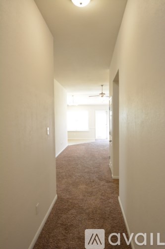 A long hallway with a carpeted floor and white walls.