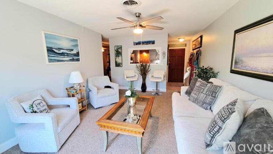 A living room with a white couch, a wooden coffee table, and a ceiling fan.