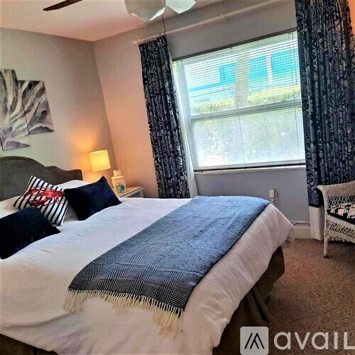 A bedroom with a large bed and a ceiling fan.