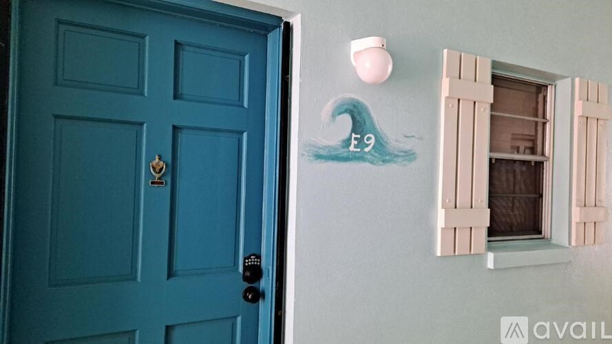 A blue door with a white window on the wall.