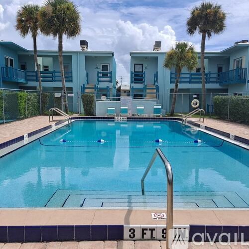 A swimming pool in front of a building with a sign that says 3 FT 9 IN.