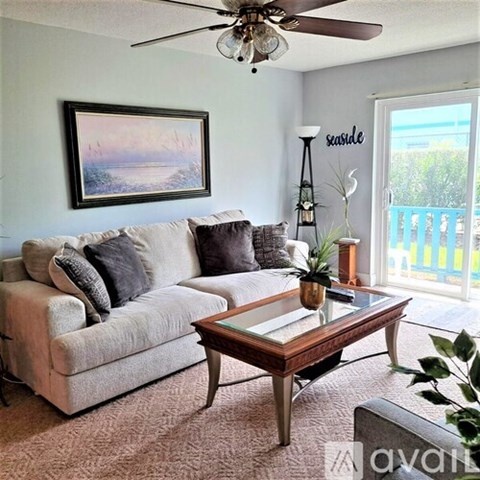 A living room with a couch, coffee table, and a painting on the wall.