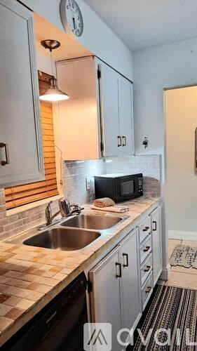 A kitchen with a sink and a microwave.