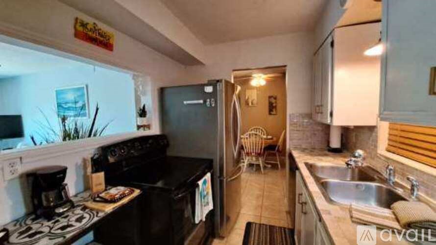 A kitchen with a black stove top oven and a black fridge.