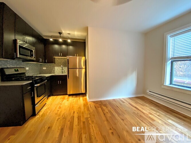 A kitchen with wooden floors and stainless steel appliances.