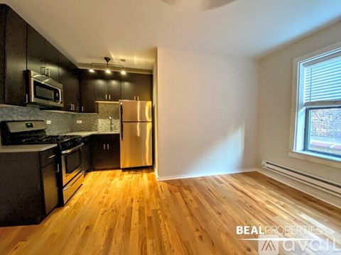 A kitchen with wooden floors and stainless steel appliances.
