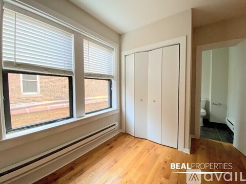A room with a large window and wooden flooring.