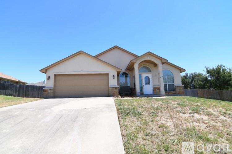 A two-story house with a garage and a driveway.