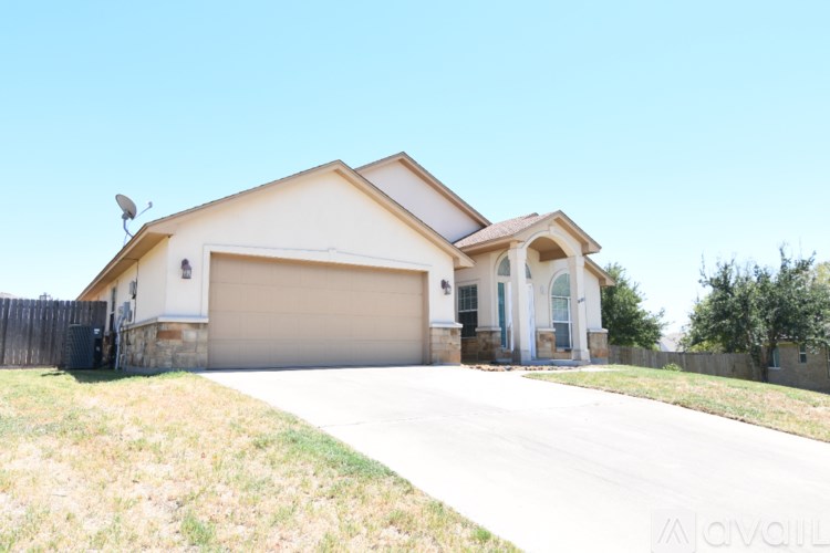 A house with a garage and a driveway in front of it.