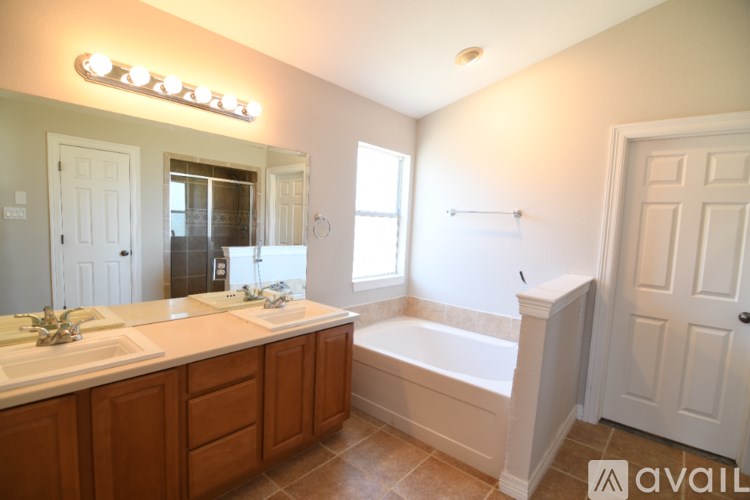 A bathroom with a tub, sink, and mirror.