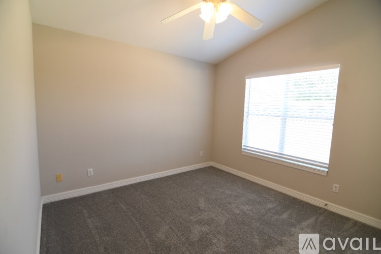 A room with a ceiling fan and a window with blinds.
