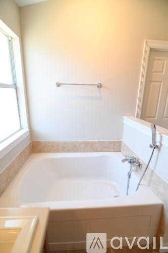 A bathroom with a tub and a window.