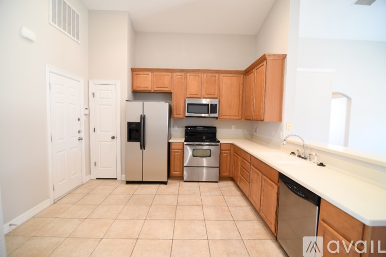 A kitchen with wooden cabinets and a tiled floor.