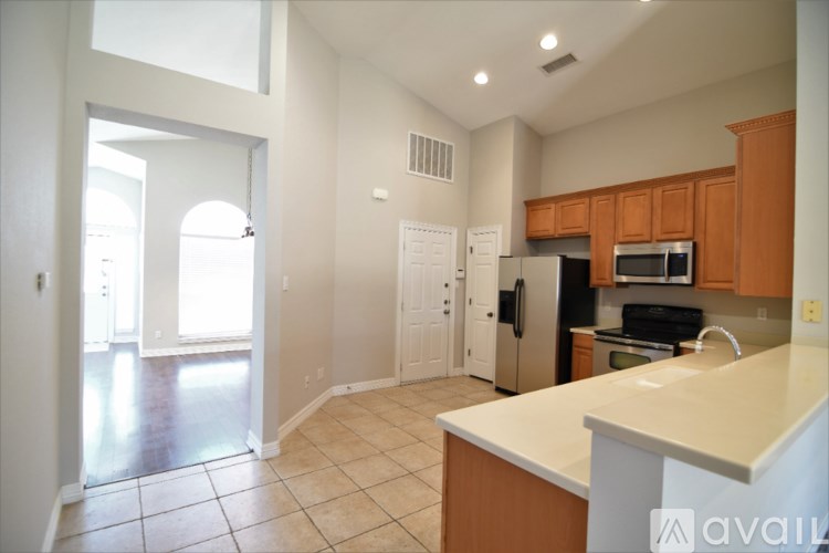 A kitchen with white countertops and wooden cabinets.